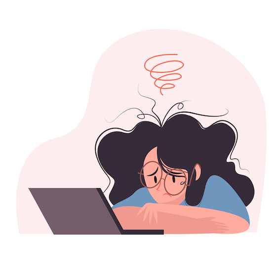 femme penchée sur son bureau devant son ordinateur, avec une expression triste